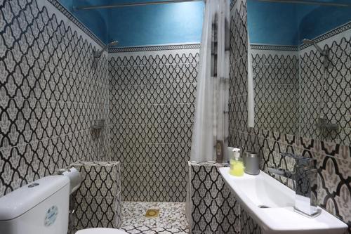 a bathroom with a toilet and a sink and a mirror at Riad Dwiriyat My Teib in Marrakech