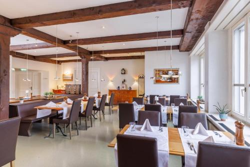 a restaurant with wooden ceilings and tables and chairs at Sorell Hotel Sonnental Dübendorf in Dübendorf