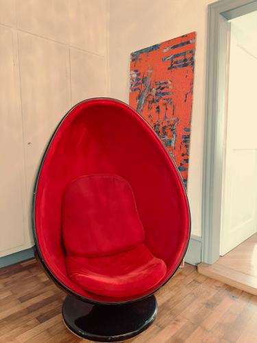 a red chair is sitting in a room at Designwohnung am Schloss in Weilburg