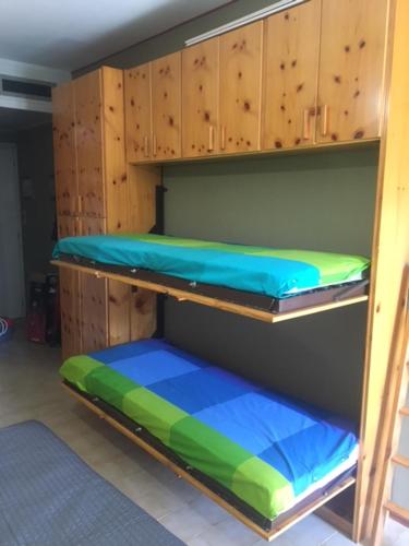 a room with wooden bunk beds with blue and green at Garessio 2000 primo residence Montagna e Mare in Garessio