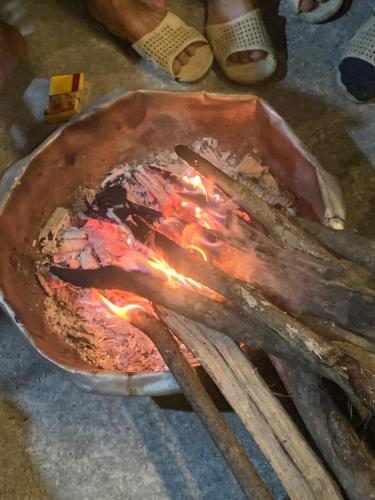 a pot with fire on top of a table at Nhà Cổ Bản Giốc Homestay - Làng đá Khuổi Ky in Bản Piên