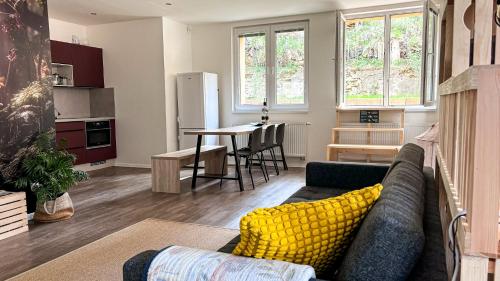 a living room with a couch and a kitchen with a table at Remote Work Friendly Zahradní apartmán u jezera in Staré Splavy