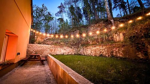 a string of lights on the side of a stone wall at Remote Work Friendly Zahradní apartmán u jezera in Staré Splavy