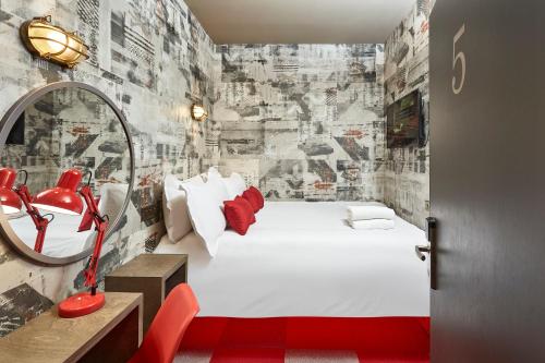 ein Schlafzimmer mit einem großen weißen Bett und einem roten Stuhl in der Unterkunft The Pier Rooms in Oban