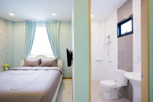 a bedroom with a bed and a toilet and a window at นาวาพูลวิลล่าหัวหิน VIP in Hua Hin