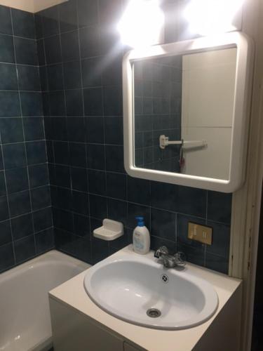 e bagno con lavandino, specchio e vasca. di Garessio 2000 primo residence Montagna e Mare a Garessio