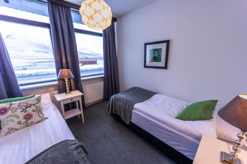 1 dormitorio con 2 camas y ventana en The Northern Comfort Inn en Ólafsfjörður