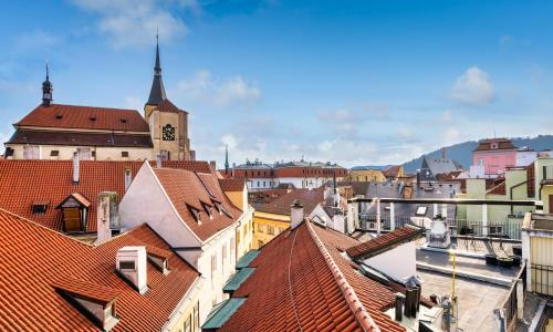 a view of a city with roofs and a clock tower at Hotel "Palác U Kočků" by Adrez, Palace At the Cats in Prague