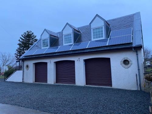 a house with solar panels on top of it at WHITEHILL STABLES in Kirknewton