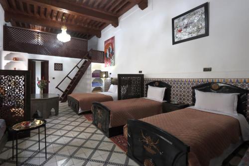 a hotel room with two beds and a staircase at Riad Dwiriyat My Teib in Marrakesh