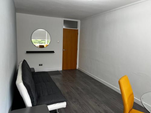 a living room with a couch and a table and a mirror at Stylish Stays - Luxury Apartment for 3 in Manchester