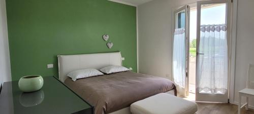 een groene slaapkamer met een bed en een glazen tafel bij Residenza Ca' Margherita Noale Venezia in Noale