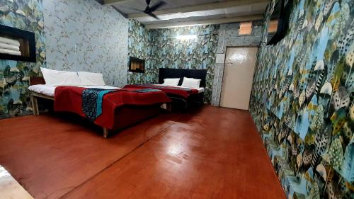 Taj City Hotel في آغْرا: غرفة نوم بسريرين وجدار بورق جدران