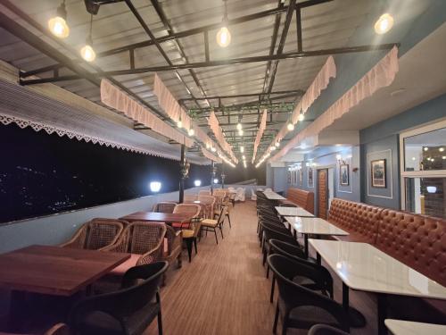 Un comedor con mesas y sillas en un restaurante. en Maplewood Hotel & Spa, en Gangtok