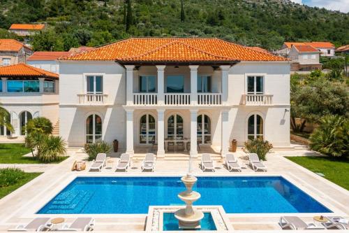 a villa with a swimming pool and a house at La Villa Dubrovnik in Trsteno