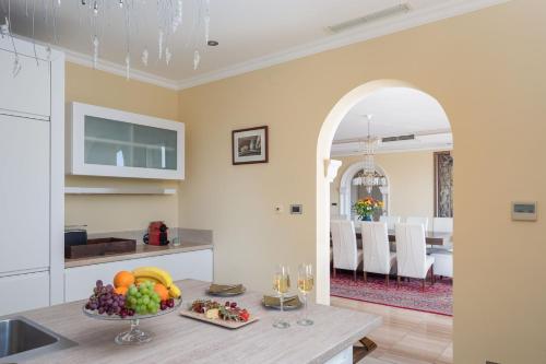 a kitchen with a table with a bowl of fruit at La Villa Dubrovnik in Trsteno