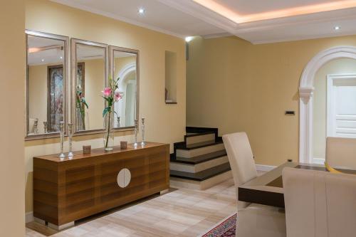 a living room with a table and a mirror at La Villa Dubrovnik in Trsteno