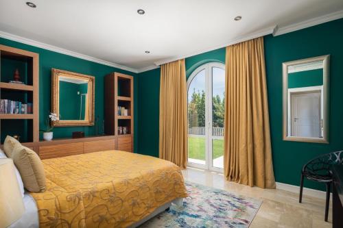a bedroom with green walls and a bed and a window at La Villa Dubrovnik in Trsteno