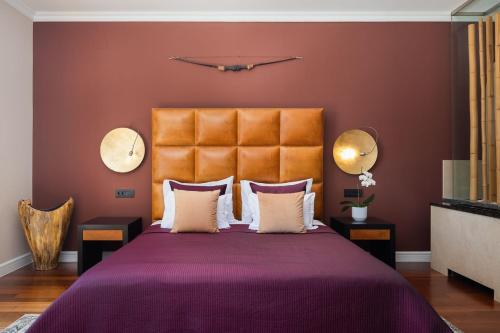 a bedroom with a purple bed with a orange headboard at La Villa Dubrovnik in Trsteno