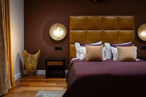 a bedroom with a bed with a large headboard at La Villa Dubrovnik in Trsteno