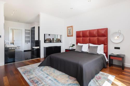 a bedroom with a large bed with a red headboard at La Villa Dubrovnik in Trsteno
