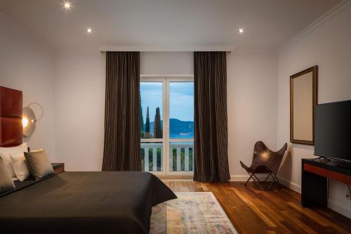 a hotel room with a bed and a large window at La Villa Dubrovnik in Trsteno