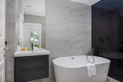 a bathroom with a white tub and a sink at La Villa Dubrovnik in Trsteno