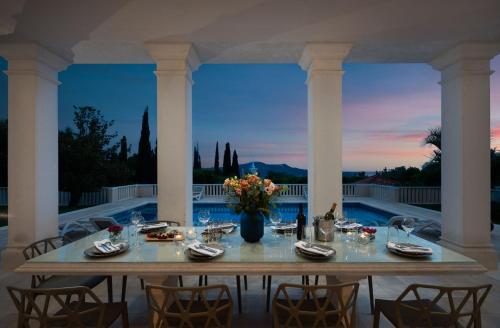 a dining table on a patio with a view at La Villa Dubrovnik in Trsteno