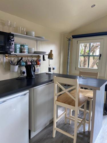 a kitchen with a counter and a table and a chair at The Cosy Cabin by the shore in Galway