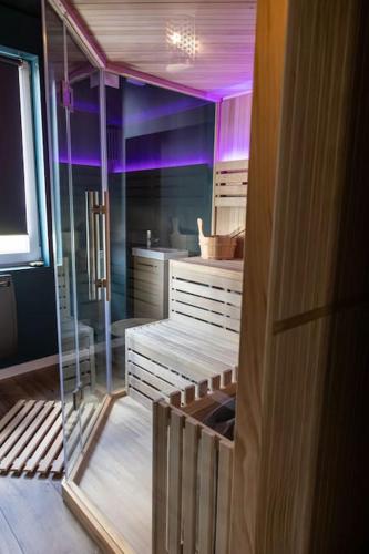 La salle de bains est pourvue d'un éclairage violet et d'une porte en verre. dans l'établissement Le Street, à Calais