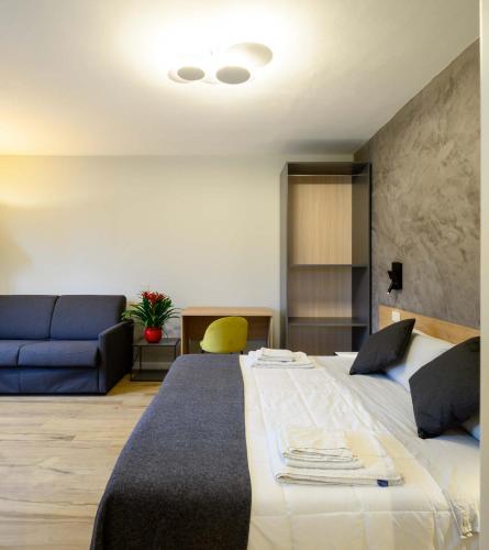 a bedroom with a large bed and a blue couch at B&B Dimora Morelli in Gubbio