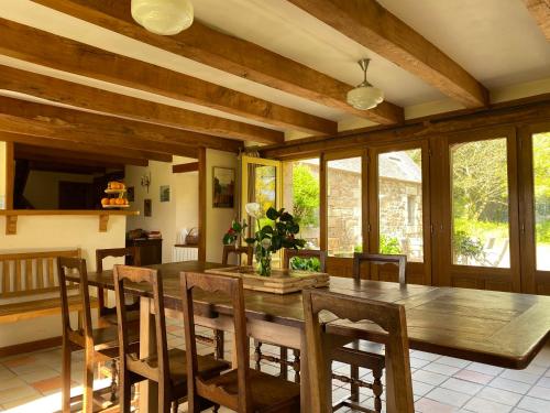 une salle à manger avec une table et des chaises en bois dans l'établissement Maison authentique - mer et campagne - 6 couchages ou 12 couchages, à Pleumeur-Bodou