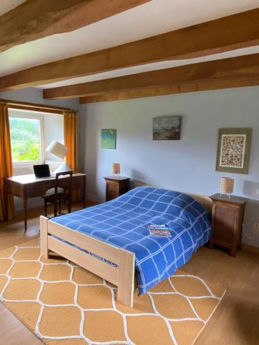 - une chambre avec un lit bleu et un bureau dans l'établissement Maison authentique - mer et campagne - 6 couchages ou 12 couchages, à Pleumeur-Bodou