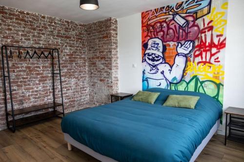 Un dormitorio con una cama azul con una pared pintada en Le Street en Calais