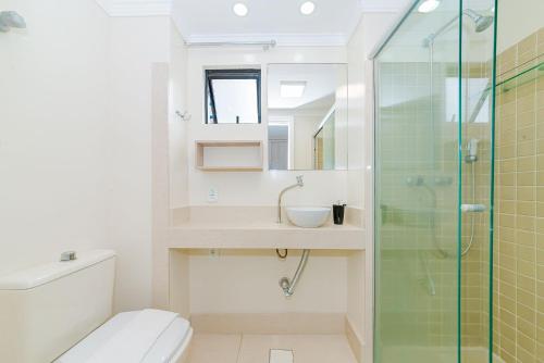 ein Bad mit einem WC, einem Waschbecken und einer Dusche in der Unterkunft Amplo Apto 2sui+1Q Vista Mar 50m da Praia in Balneário Camboriú