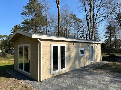 a small shed with a roof on a driveway at Vakantiepark Hertenhorst in Beekbergen