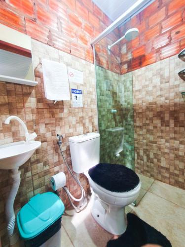 a bathroom with a shower and a toilet and a sink at Babylon Village in Algodoal