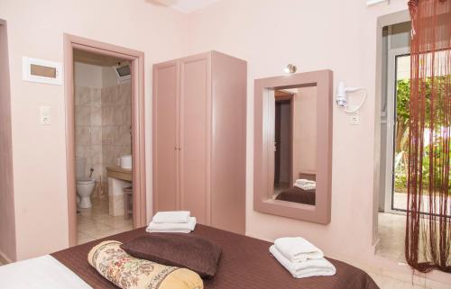 a bedroom with a bed and a bathroom with a mirror at Fantastic Matala 1 in Matala