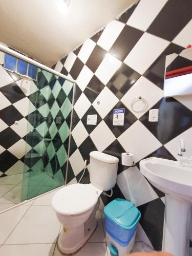 a bathroom with a toilet and a sink at Babylon Village in Algodoal
