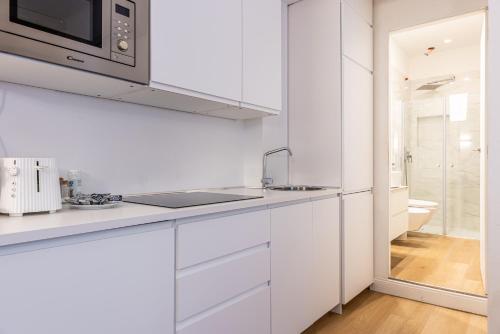 ミラノにあるSant'Andrea Charme Apartmentsの白いキッチン(シンク、電子レンジ付)