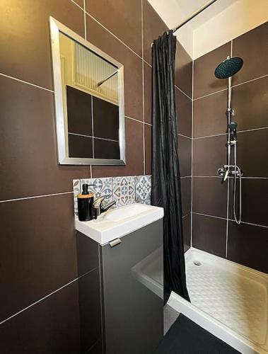 ein Bad mit einem Waschbecken und einer Dusche in der Unterkunft Nuit d'amour in Ermont