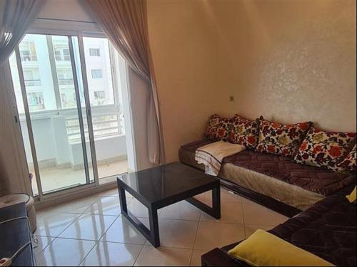 een woonkamer met een bank en een salontafel bij Agadir, Simple mais confortable in Agadir