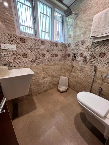 a bathroom with a white toilet and a sink at The G.S. Cottages in Shimla