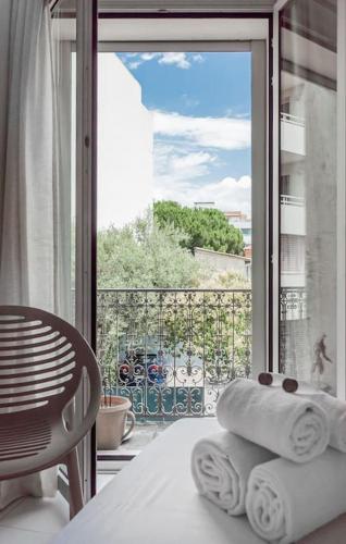 une pile de serviettes sur une table devant une fenêtre dans l'établissement La Maison Mediterranéenne, T4, Terrasse, clim, pkg, à Montpellier