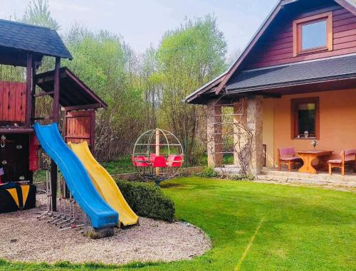 a slide in a yard next to a house at Country House Liptov in Svätý Kríž