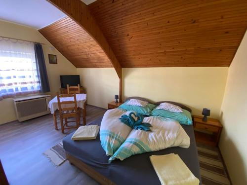 a bedroom with a bed with a wooden ceiling at Aranypatak Apartmanház Hévíz in Hévíz