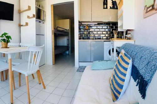 a room with a bed and a table and a kitchen at Magnifique T2 - Le Lagon bleu in Le Grau-du-Roi