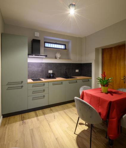 a kitchen with a table with a red table cloth at B&B Dimora Morelli in Gubbio