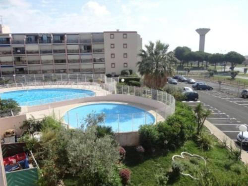une grande piscine devant un immeuble dans l'établissement Magnifique T2 - Le Lagon bleu, au Grau-du-Roi