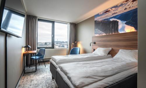 Habitación de hotel con cama, escritorio y ventana en Thon Partner Stavanger Forum Hotel en Stavanger